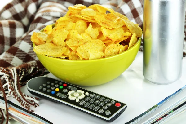 Chips in Schüssel, Zeitschriften, Plaid und TV-Fernbedienung Nahaufnahme — Stockfoto