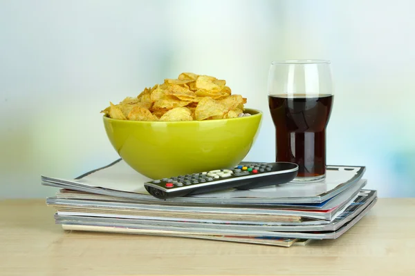 Kase, cola ve tv uzaktan oda zemin üzerine tahta masada çipleri — Stok fotoğraf