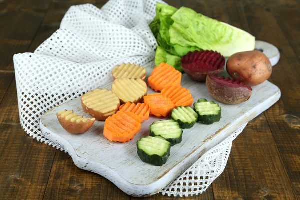 Красивые нарезанные овощи, на разделочной доске, на цветном фоне — стоковое фото
