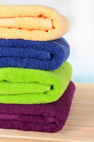 Bright towels on table on light background — Stock Photo, Image