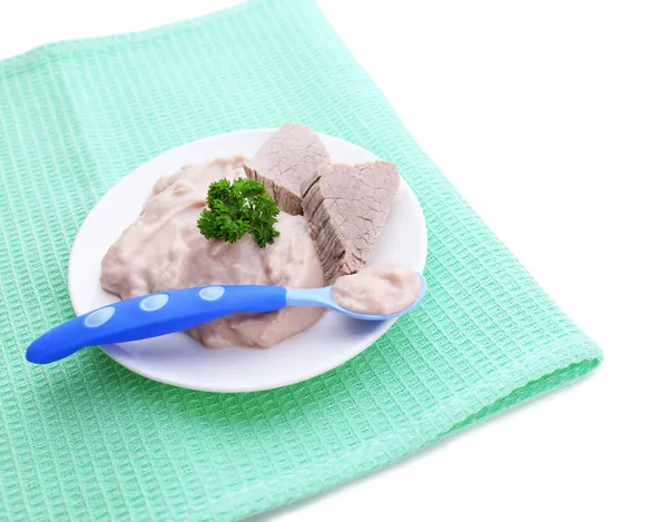 Мясная паста для кормления младенцев, на тарелке, на цветной салфетке, изолированная на белом — стоковое фото