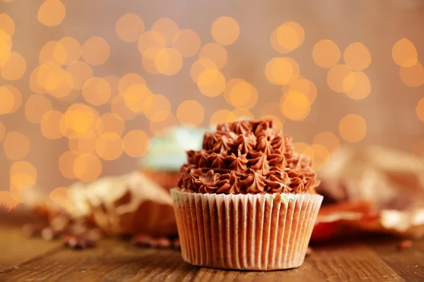 Leckere Cupcakes mit Buttercreme, auf Holztisch, auf Lichtern Hintergrund — Stockfoto