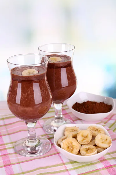 Cocktails mit Banane und Schokolade auf Tisch vor hellem Hintergrund — Stockfoto