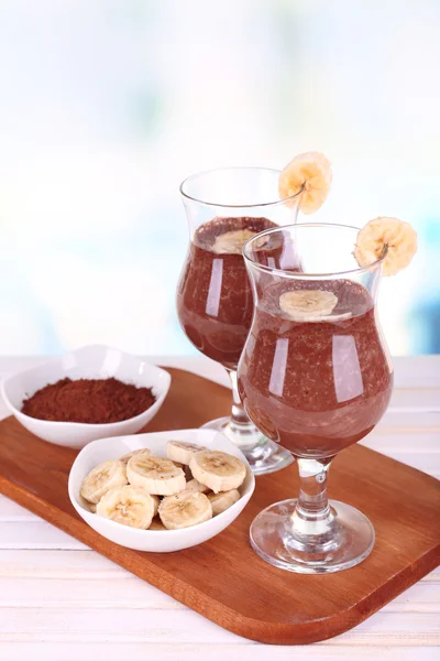 Cocktails with banana and chocolate on table on light background — Stock Photo, Image