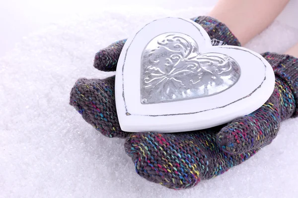 Kobieta ręce rękawice z serca na tle śniegu — Zdjęcie stockowe