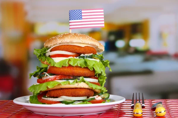 Hamburger enorme sul piatto di colore e vetro di bevanda fredda, su sfondo luminoso — Foto Stock