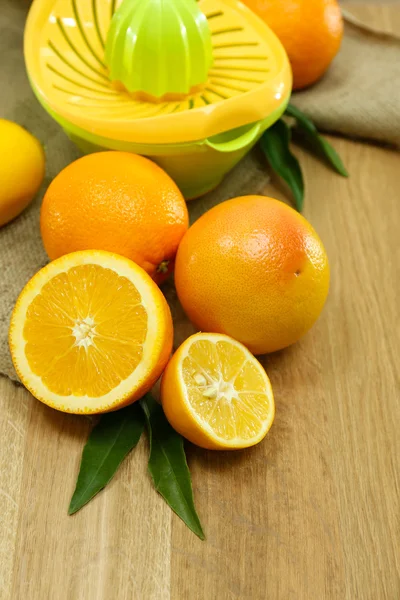 Imprensa de citrinos e frutas em fundo de madeira — Fotografia de Stock