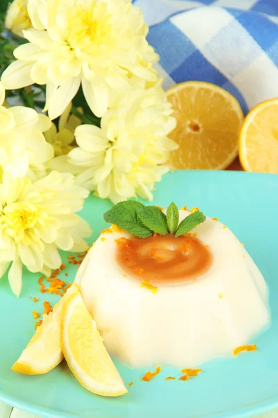 Лимон Panna Cotta с апельсиновой цедрой и карамельным соусом, на фоне цвета дерева — стоковое фото