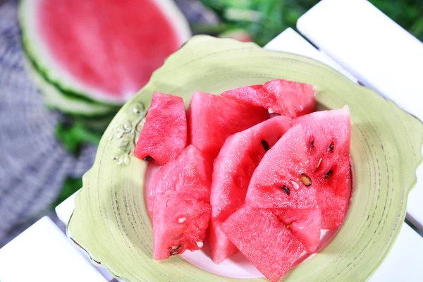 Vandmelon skiver på plade på bordet på græs baggrund - Stock-foto