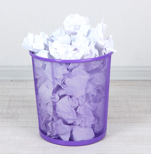 Recycle bin filled with crumpled papers, on floor — Stock Photo, Image