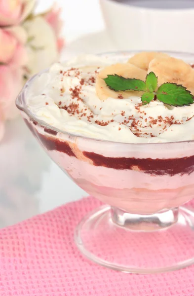 Deliciosa sobremesa com banana e caramelo na mesa sobre fundo branco — Fotografia de Stock