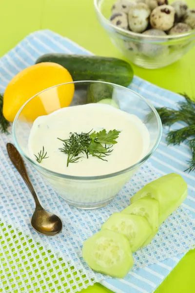 Gurkenjoghurt in Glasschale, auf Farbserviette, auf Holzgrund — Stockfoto