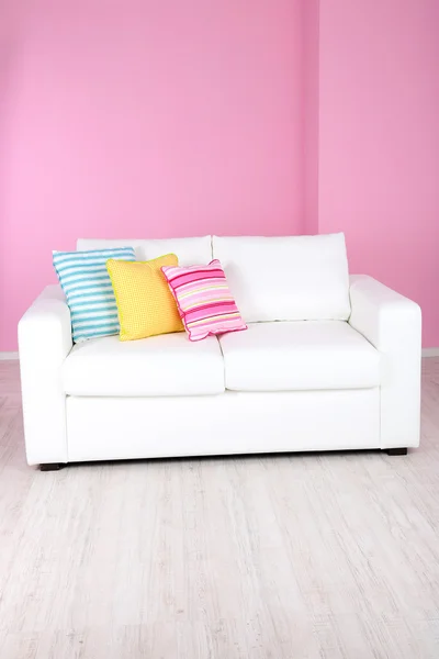 Sofá blanco en la habitación sobre fondo rosa — Foto de Stock