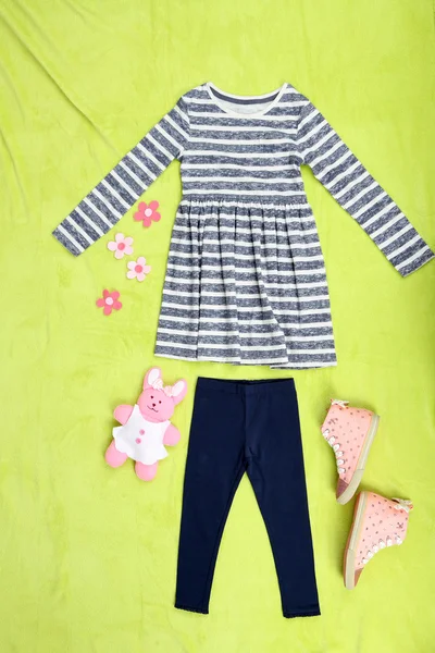 Красивая одежда для маленькой девочки на зеленом фоне — стоковое фото