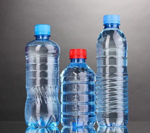 Botellas de plástico de agua sobre fondo gris —  Fotos de Stock