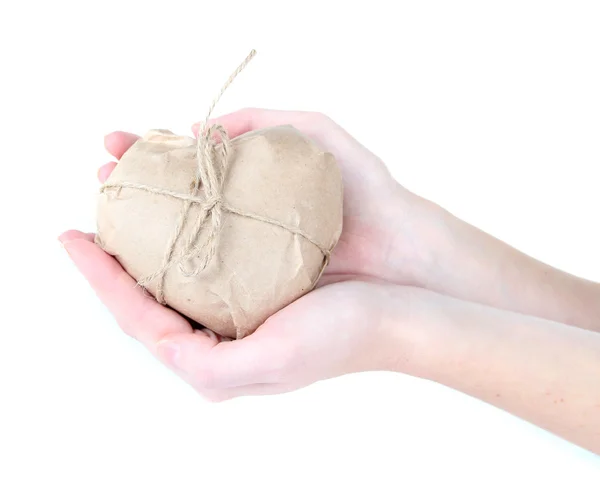 Woman hands holding a heart wrapped in brown kraft paper, isolated on white — Stock Photo, Image