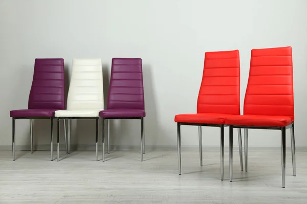 Современные цветные стулья на фоне стен — стоковое фото