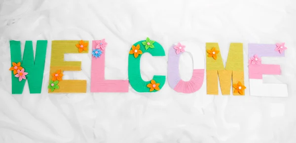 Word Welcome dibuat dengan warna cerah merajut halaman pada kain latar belakang — Stok Foto