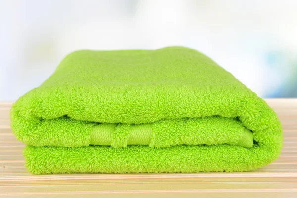 Green towel on table on light background — Stock Photo, Image
