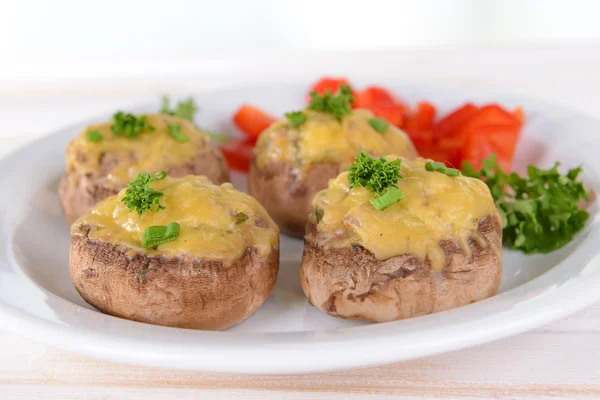 Champiñones rellenos en plato sobre mesa sobre fondo claro — Foto de Stock