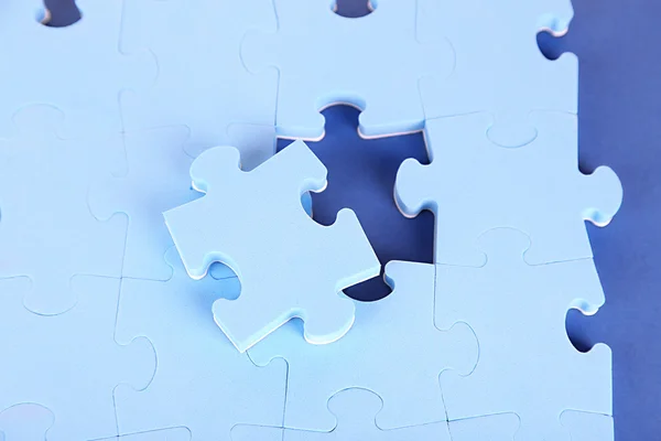 Laatste stuk van jigsaw puzzle, close-up, op blauwe achtergrond — Stockfoto