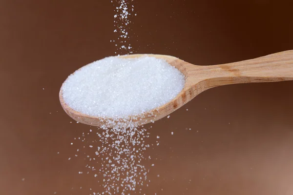 Sugar on brown background — Stock Photo, Image