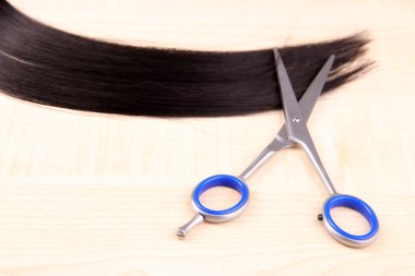 uzun kahverengi saçlı, ahşap arka plan için makaslar