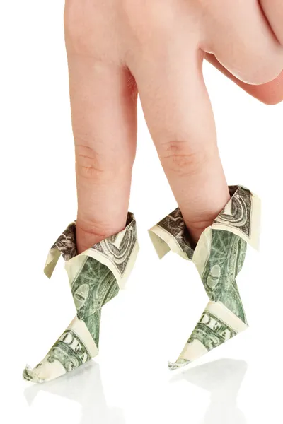 Доллары складываются в сапоги на пальцах женской руки, изолированной на белом — стоковое фото