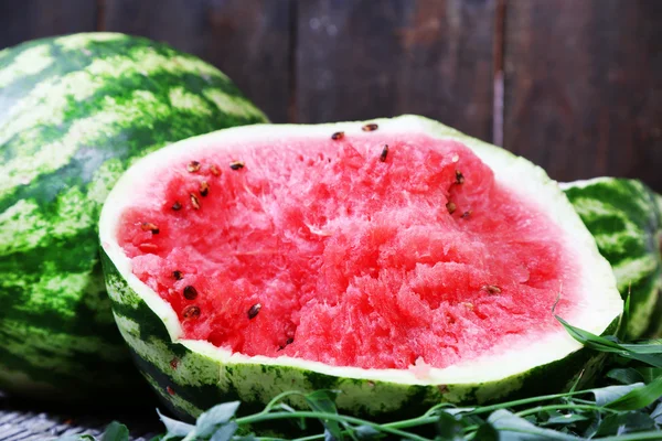 Ripe watermelons on wicker tray on grass near fence — Stock Photo, Image