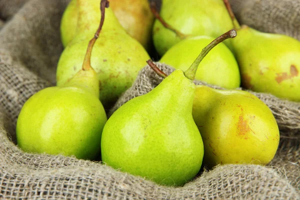 Pears on cutting board, on sackcloth background — Stock Photo, Image