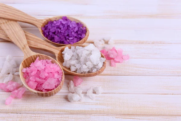 Wooden spoons with sea salt, on color wooden background — Stock Photo, Image