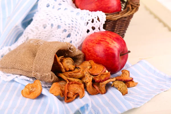 Dried apples and fresh apples, on napkin, on white wooden background — Stock Photo, Image