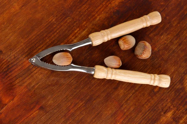 Nussknacker mit Nüssen auf Holztisch in Großaufnahme — Stockfoto