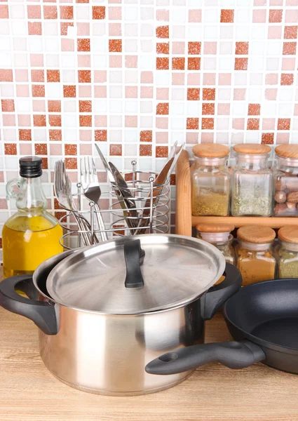 Pot and pan in kitchen on table on mosaic tiles background — Stock Photo, Image
