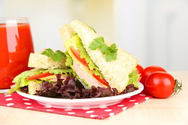 Свежие и вкусные сэндвичи на тарелке на светлом фоне — стоковое фото