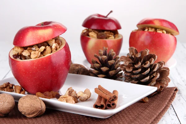 Stuffed apples with nuts and cinnamon on plate on table close up — Stock Photo, Image