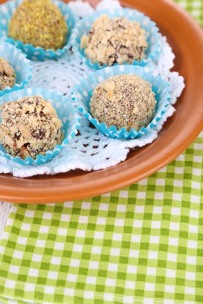 Set Schokoladenbonbons, auf Teller, auf Holzgrund — Stockfoto