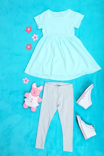 Gyönyörű ruhák, kislány, a kék háttér — Stock Fotó