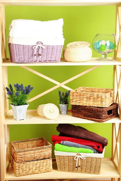 Hermosos estantes blancos con diferentes objetos relacionados con el hogar, en el fondo de la pared de color — Foto de Stock