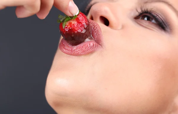 Fechar-se de mulher comendo morango em chocolate — Fotografia de Stock