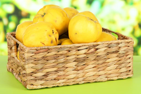 Sweet quinces in wicker basket on table on bright background — Stock Photo, Image