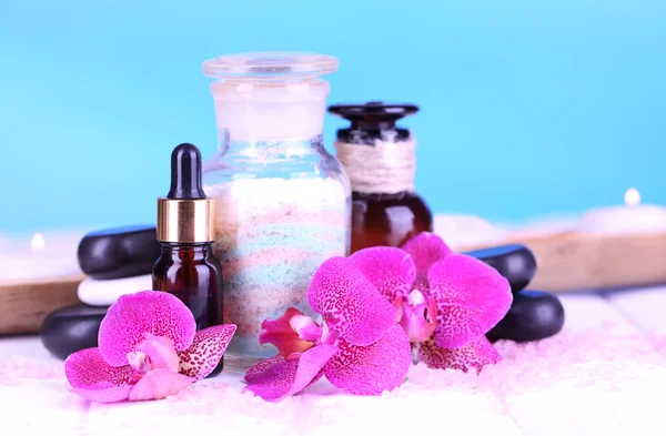 Schöne Wellness-Umgebung mit Orchidee auf weißem Holztisch auf blauem Hintergrund — Stockfoto