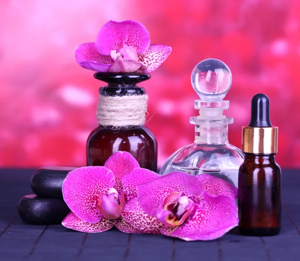 Hermoso entorno de spa con orquídea en mesa de bambú sobre fondo rojo —  Fotos de Stock
