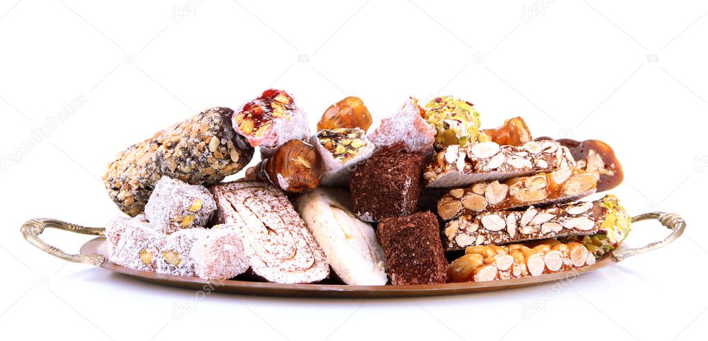 Tasty oriental sweets on metal tray, isolated on white