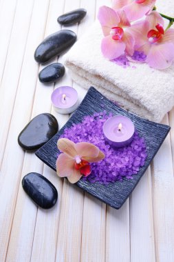 güzel çiçek ile natürmort orkide çiçek, havlu ve deniz tuzu, renk ahşap arka plan üzerine bir kase