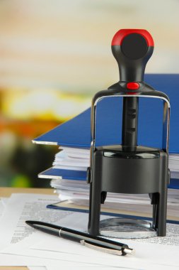 damga ile kağıtları masaya parlak arka plan üzerinde