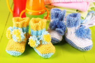 tığ işi patik bebek, elbise, şişe üzerinde ahşap arka plan ile kompozisyon
