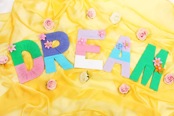 Word Dream created with brightly colored knitting yard on fabric background — Stock Photo, Image