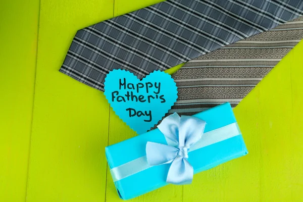 Happy Fathers Day tag with gift boxes and tie, on wooden background — Stock Photo, Image