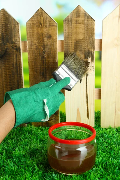 Applying protective varnish to wooden fence, on bright background — Stock Photo, Image